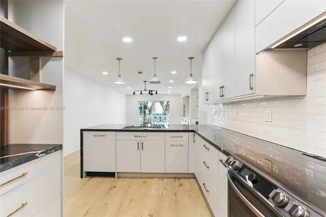 a kitchen with granite countertop white cabinets and white appliances