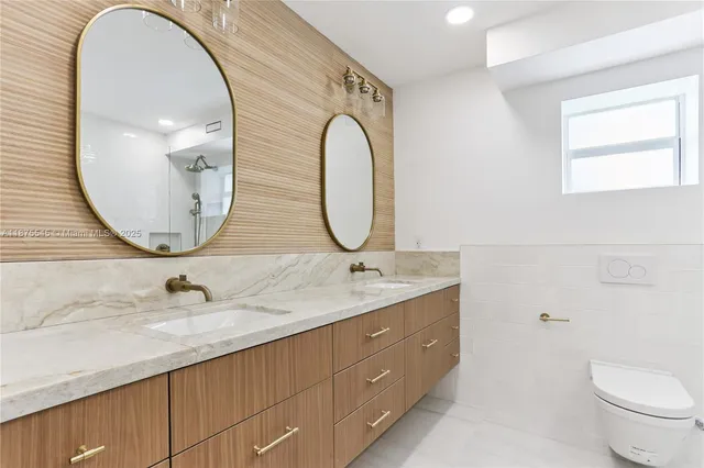 a bathroom with a granite countertop double vanity sink and a mirror