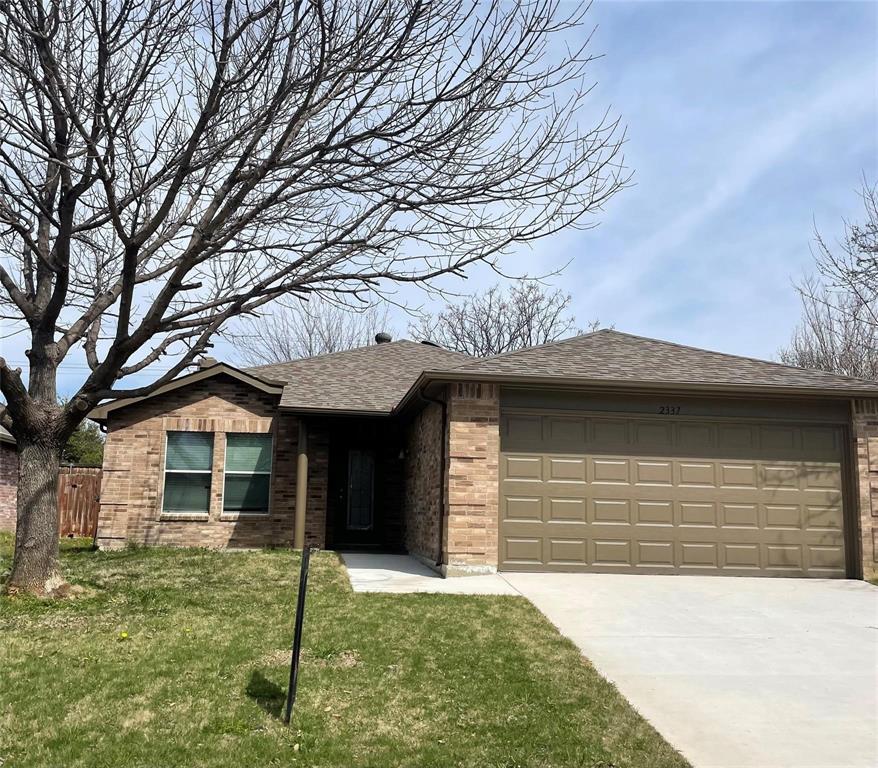 View of front of home featuring a shingled roof, brick siding, driveway, and an attached garage