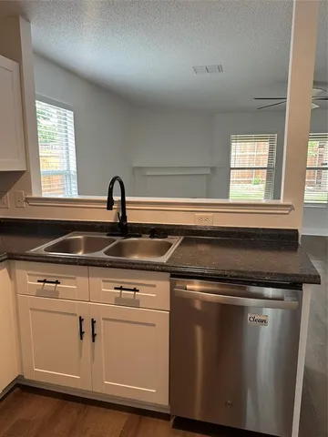 a kitchen with granite countertop a sink and cabinets