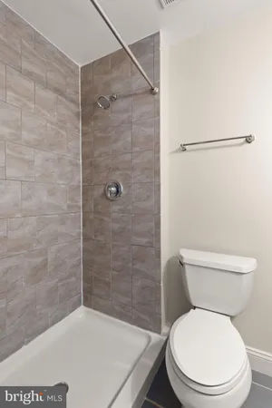 a white toilet sitting next to a bath tub and a shower