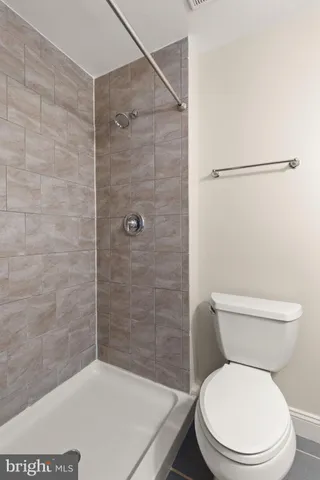 a white toilet sitting next to a bath tub and a shower