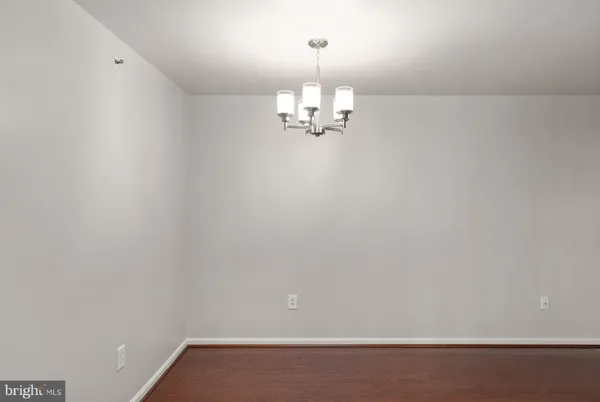 a view of a room with hardwood floor and a ceiling fan