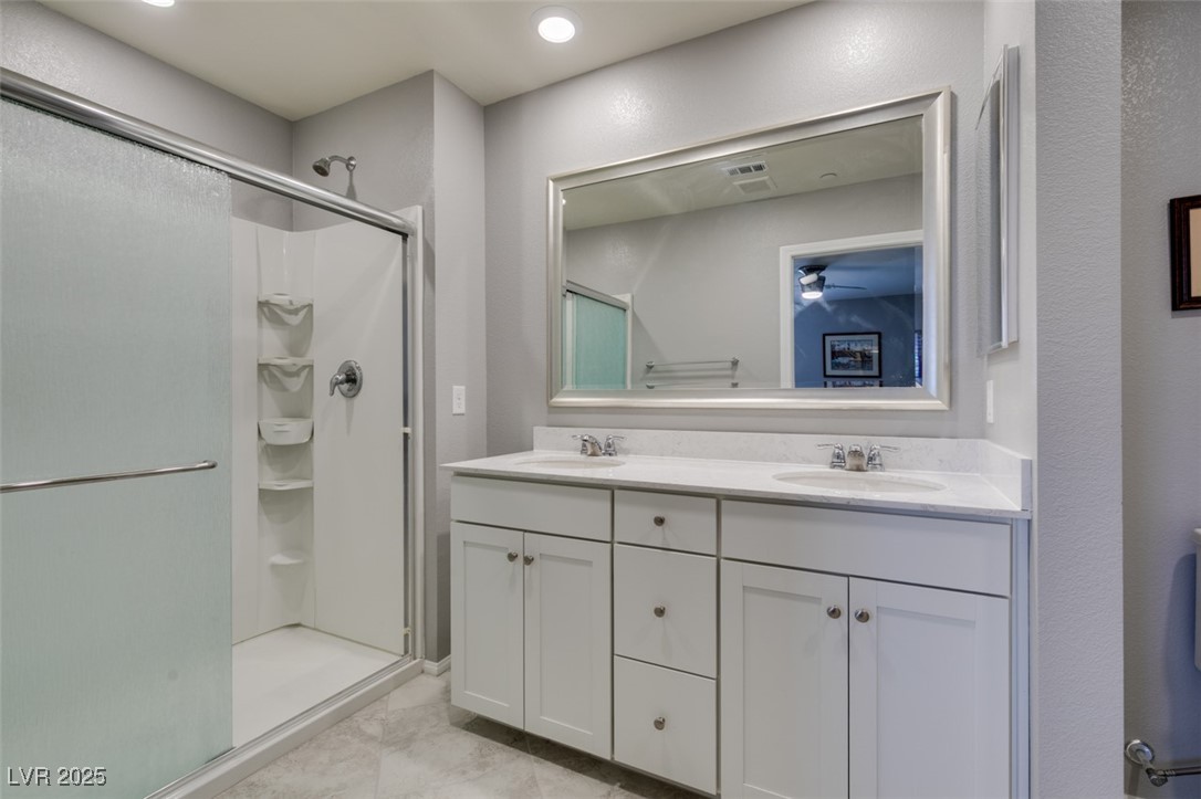 2870 Turnstone Ridge Street Henderson, NV 89044 - Photo 36 of 50 Bathroom featuring a shower stall, double vanity, and a ceiling fan