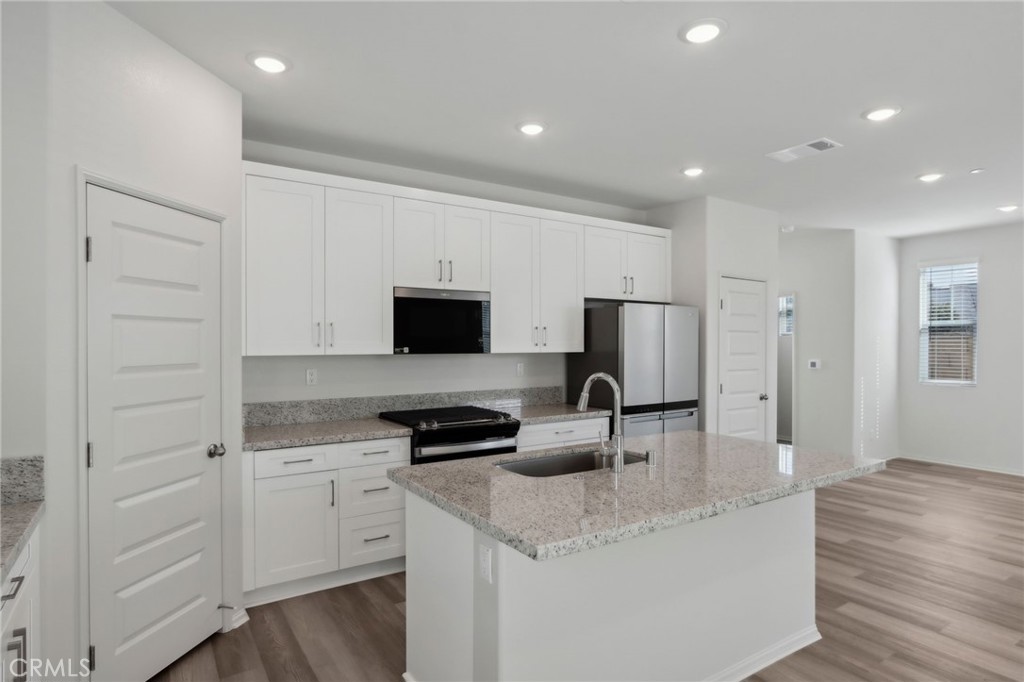 29527 Via Cosecha Temecula, CA 92591 - Photo 11 of 35 a kitchen with white cabinets and stainless steel appliances