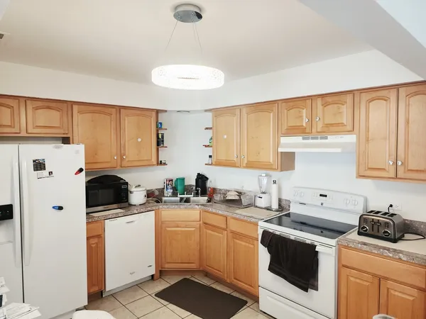 a kitchen with white cabinets sink and white appliances