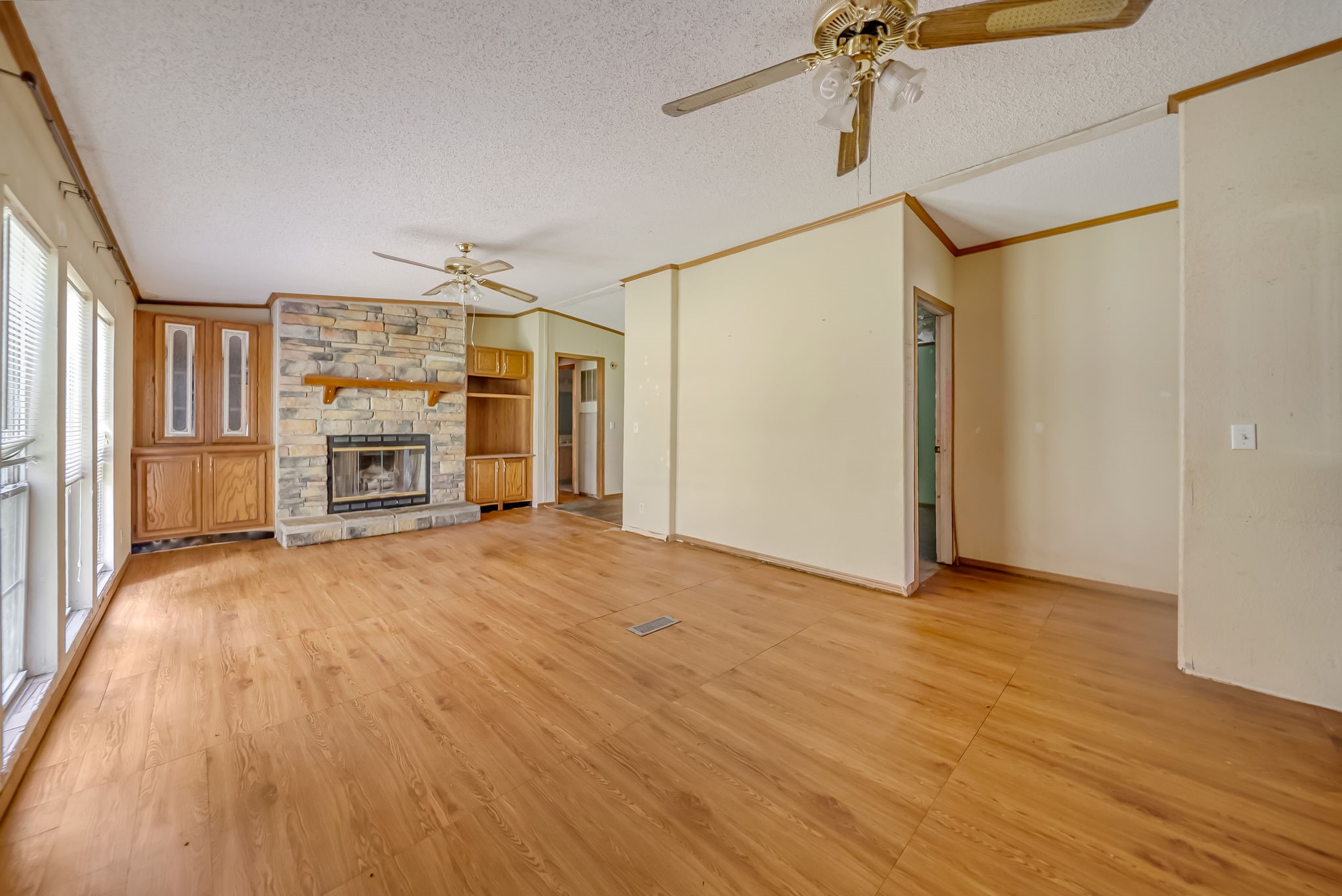 25979 Shade Tree Lane Splendora, TX 77372 - Photo 12 of 22 The spacious family room is centered around a charming floor-to-ceiling stone fireplace with built-in cabinetry, creating a warm and inviting space for everyday living and entertaining.