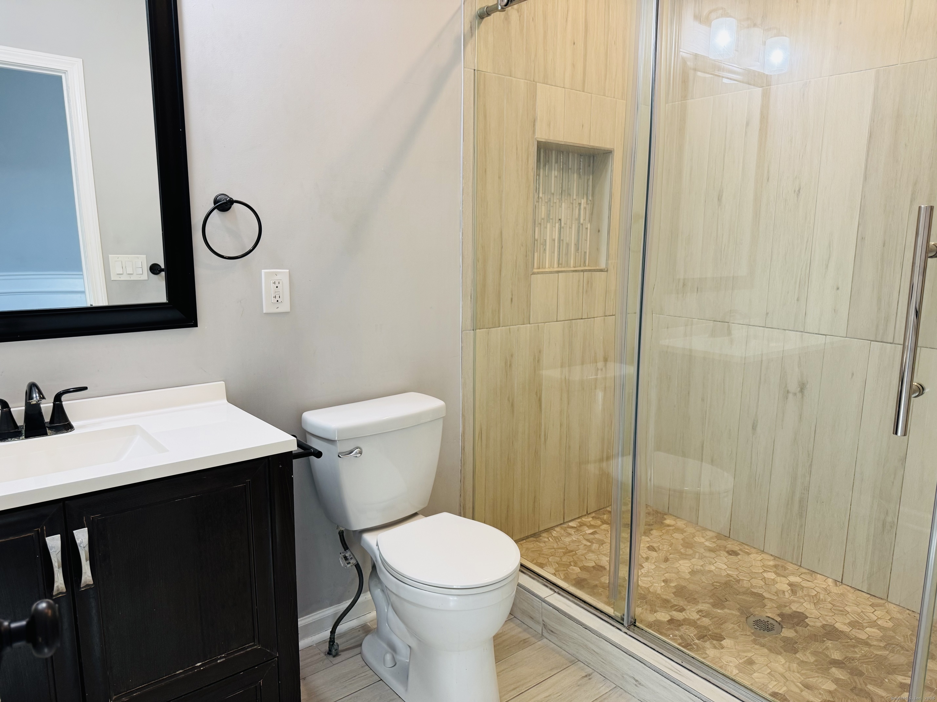 39 Bassett Street Ansonia, CT 06401 - Photo 7 of 21 a bathroom with a sink a toilet a mirror and shower
