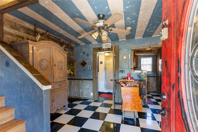 a room with lots of white furniture and a chandelier
