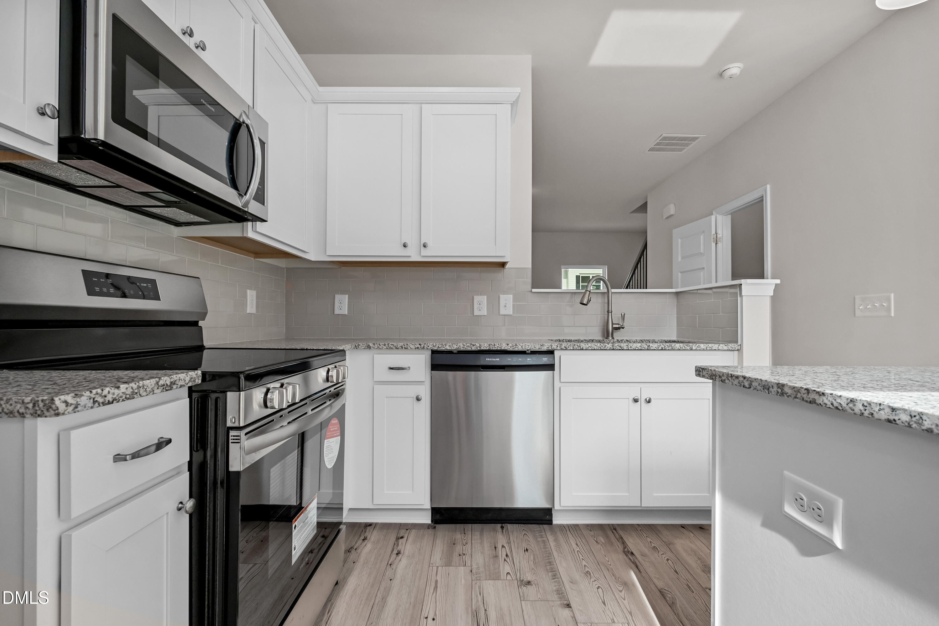 233 Courtside Drive Dunn, NC 28334 - Photo 13 of 29 a kitchen with stainless steel appliances granite countertop a stove a sink and a microwave