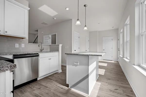a kitchen with white cabinets and sink