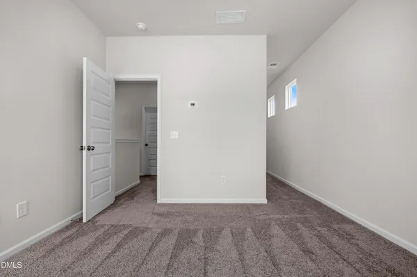 an empty room with windows and entrance to other room