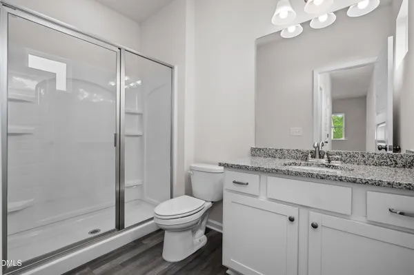 a bathroom with a granite countertop sink a toilet and a mirror