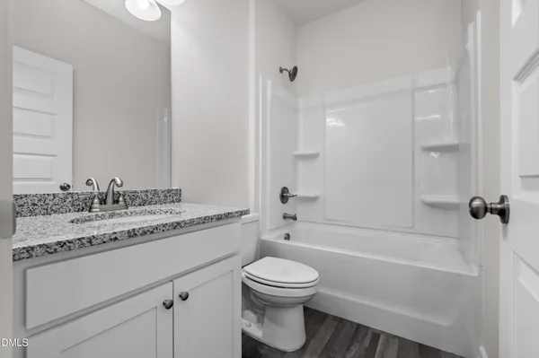 a bathroom with a granite countertop toilet a sink and a bathtub