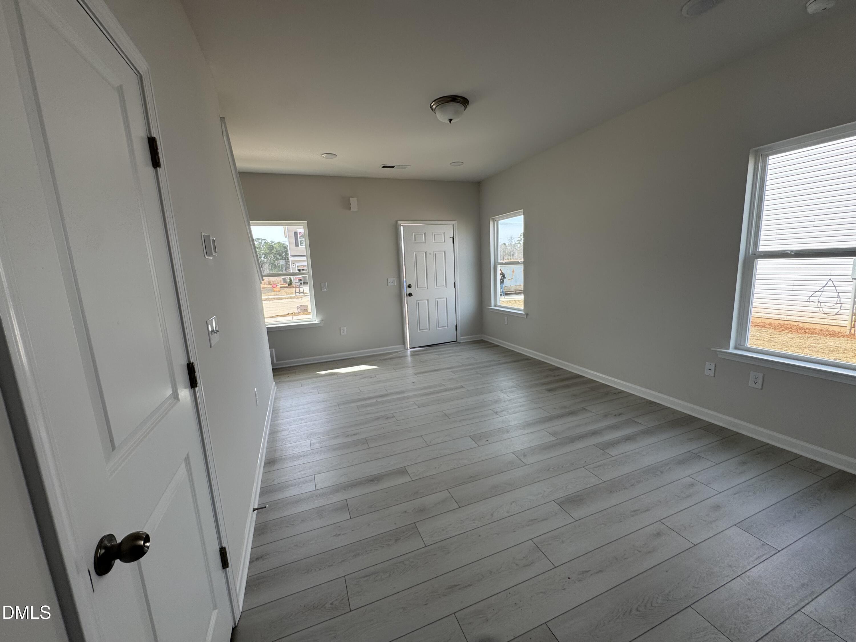 233 Courtside Drive Dunn, NC 28334 - Photo 5 of 29 an empty room with wooden floor and windows