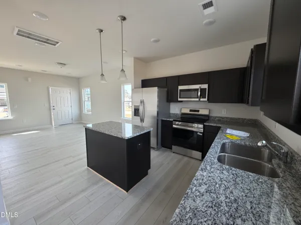 a kitchen with wooden floors and black appliances