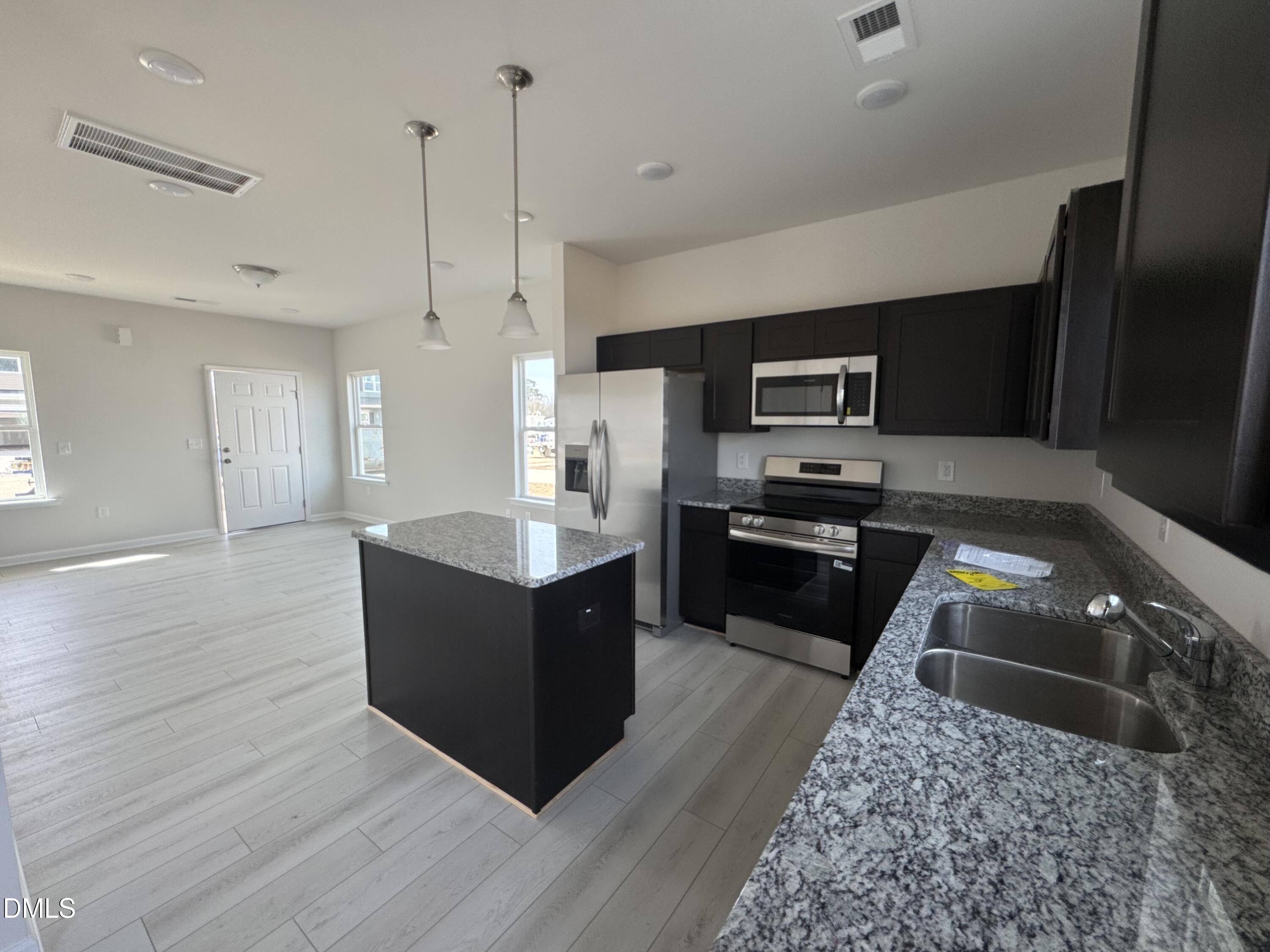 233 Courtside Drive Dunn, NC 28334 - Photo 10 of 29 a kitchen with wooden floors and black appliances