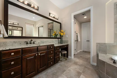 a spacious bathroom with a granite countertop sink and a mirror
