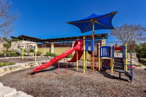 a view of a park with a slide and swing