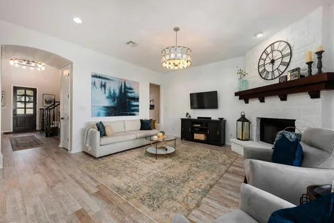 a living room with furniture a fireplace and a flat screen tv