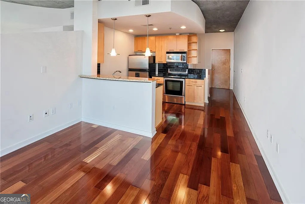 3324 Peachtree Road Northeast, Unit 2713 Atlanta, GA 30326 - Photo 2 of 29 a kitchen with wooden floor and stainless steel appliances