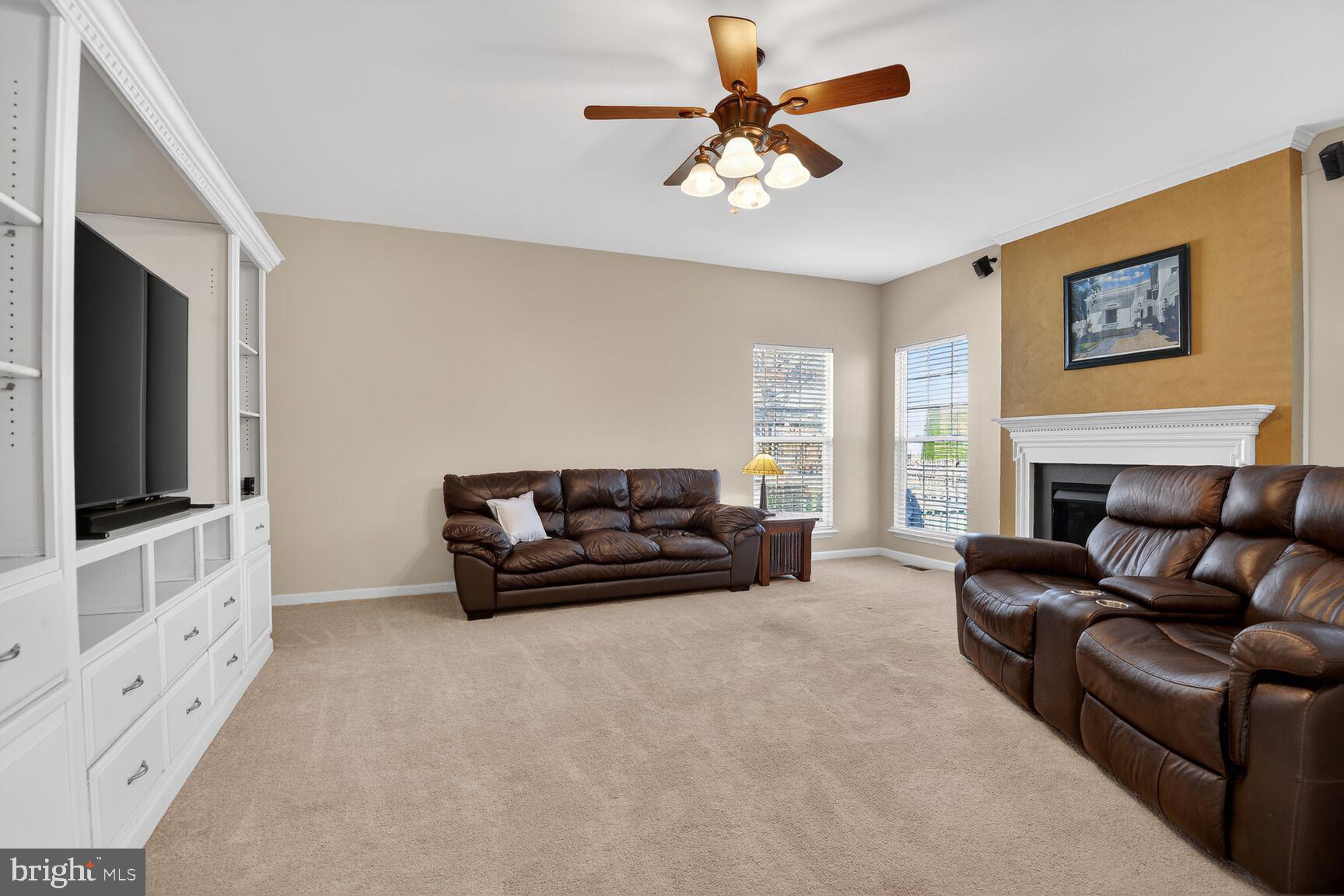 14272 Town Commons Way Gainesville, VA 20155 - Photo 12 of 32 a living room with furniture a flat screen tv and a fireplace