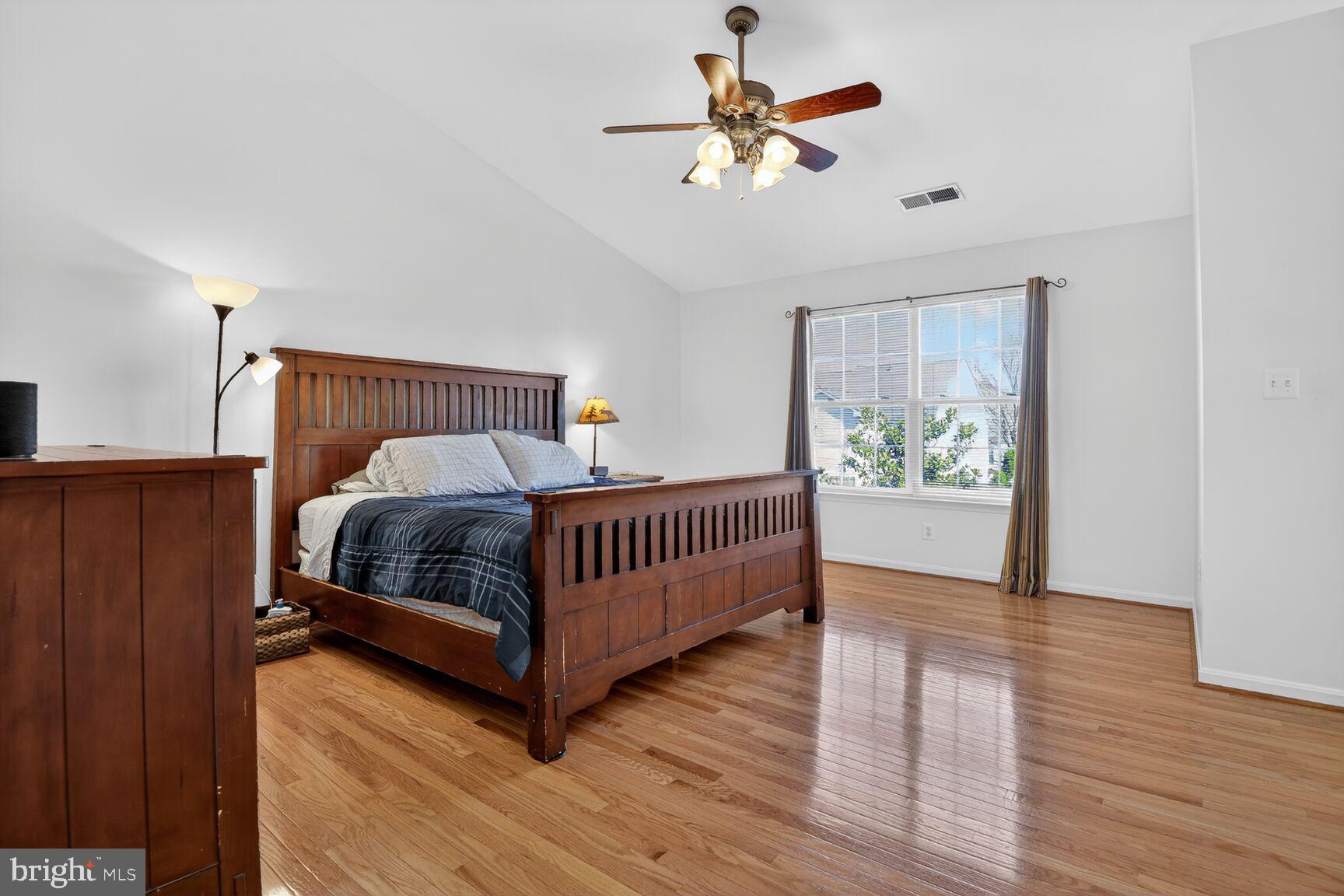 14272 Town Commons Way Gainesville, VA 20155 - Photo 15 of 32 a bedroom with a bed and a chandelier