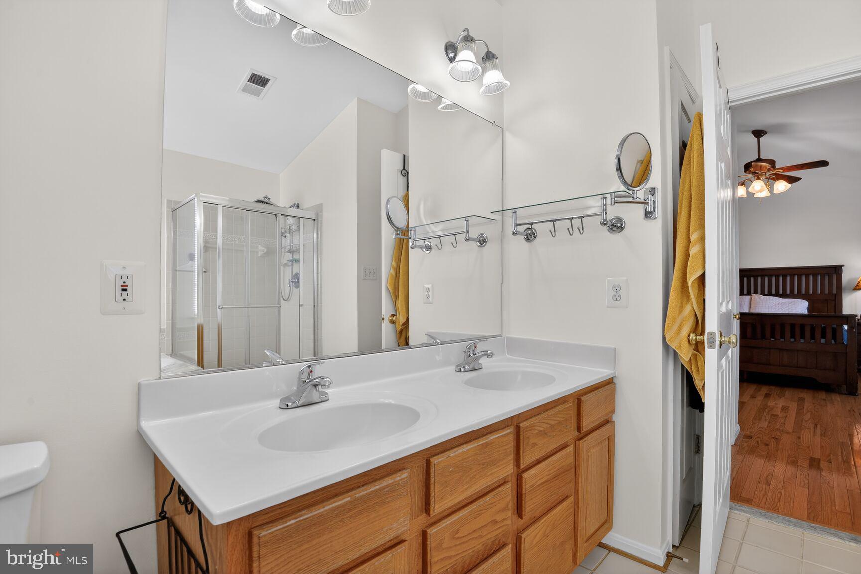 14272 Town Commons Way Gainesville, VA 20155 - Photo 18 of 32 a bathroom with a sink double vanity and a mirror