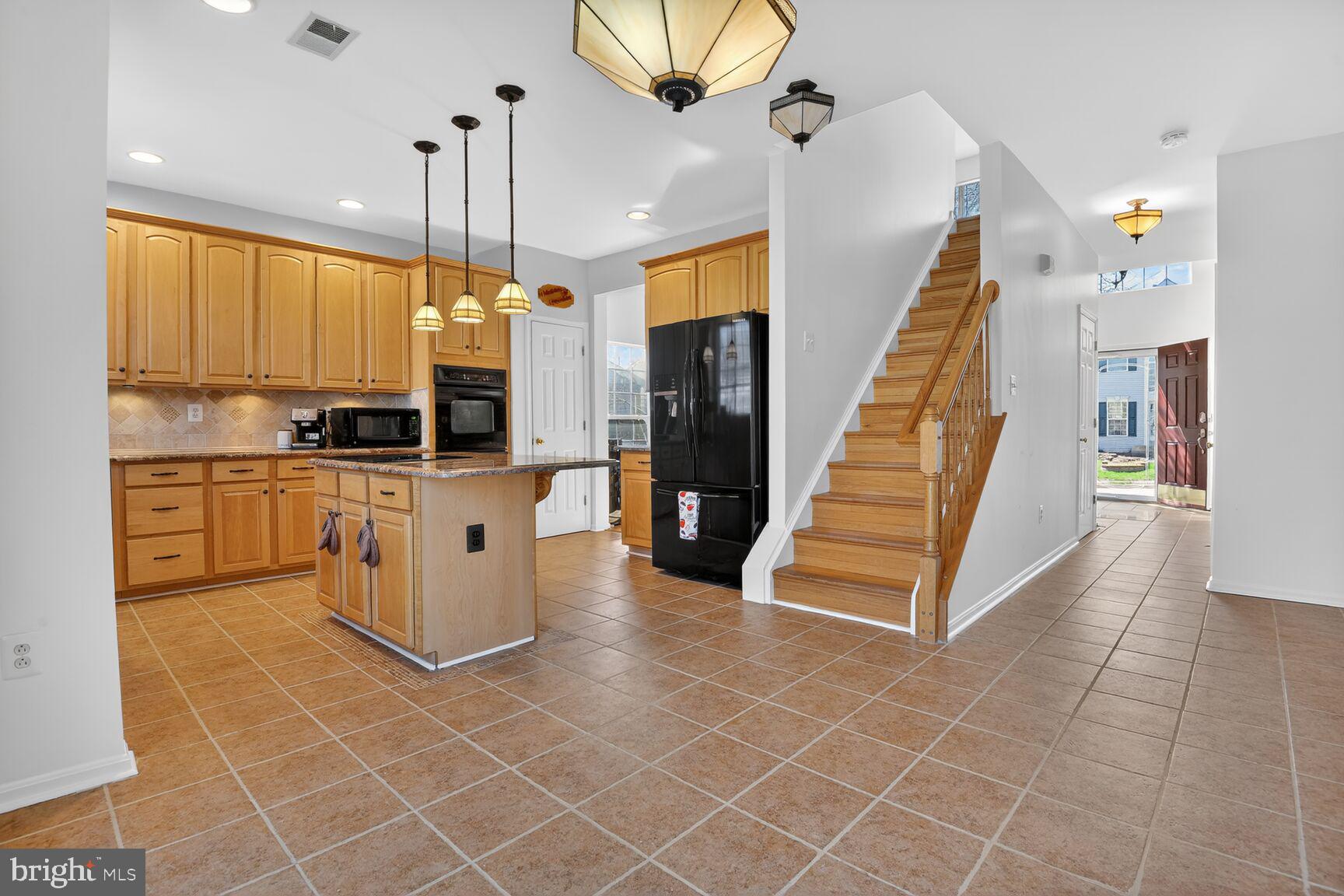 14272 Town Commons Way Gainesville, VA 20155 - Photo 5 of 32 a view of a kitchen with cabinets and a wooden floor