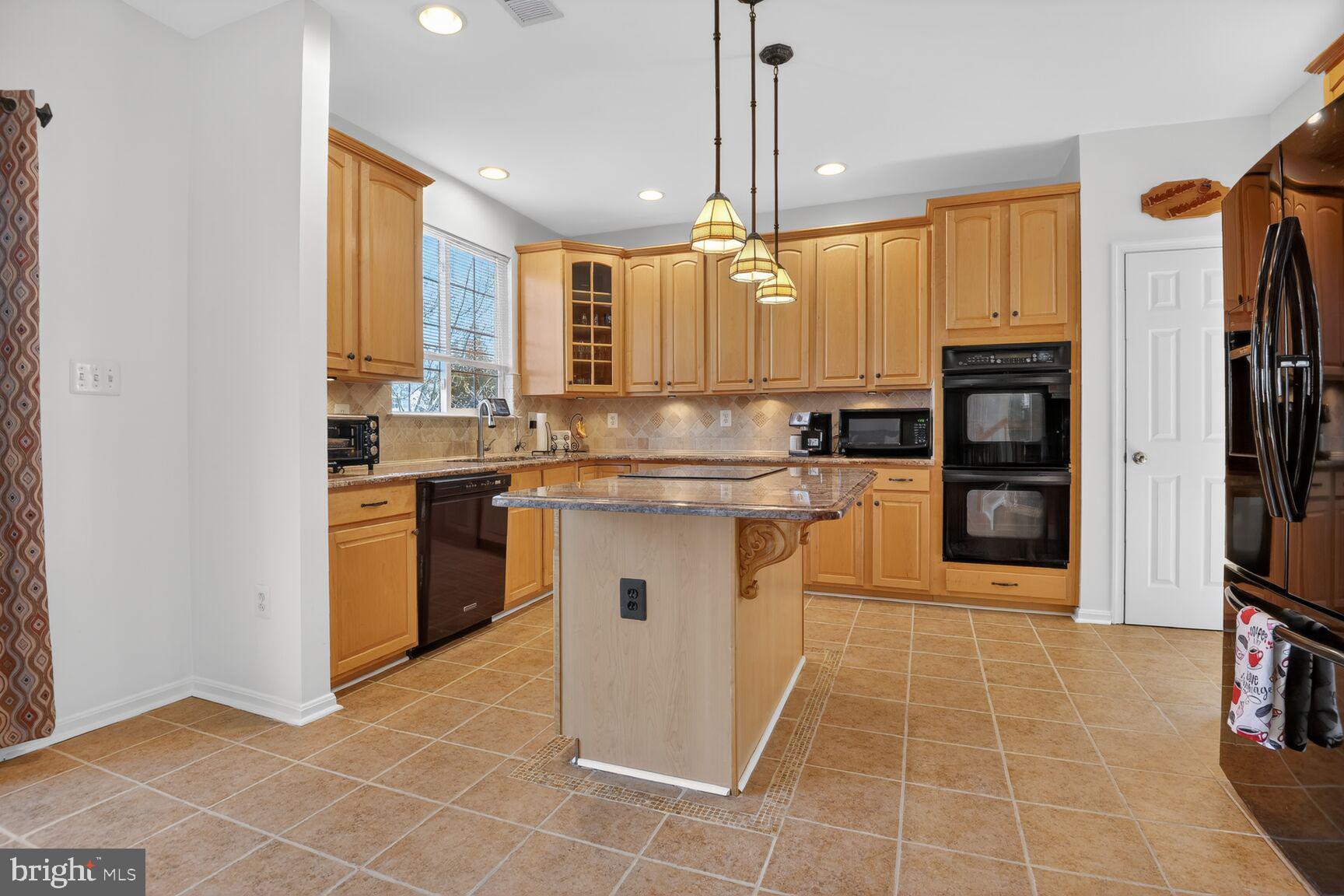 14272 Town Commons Way Gainesville, VA 20155 - Photo 6 of 32 a kitchen with a sink a counter top space cabinets and stainless steel appliances