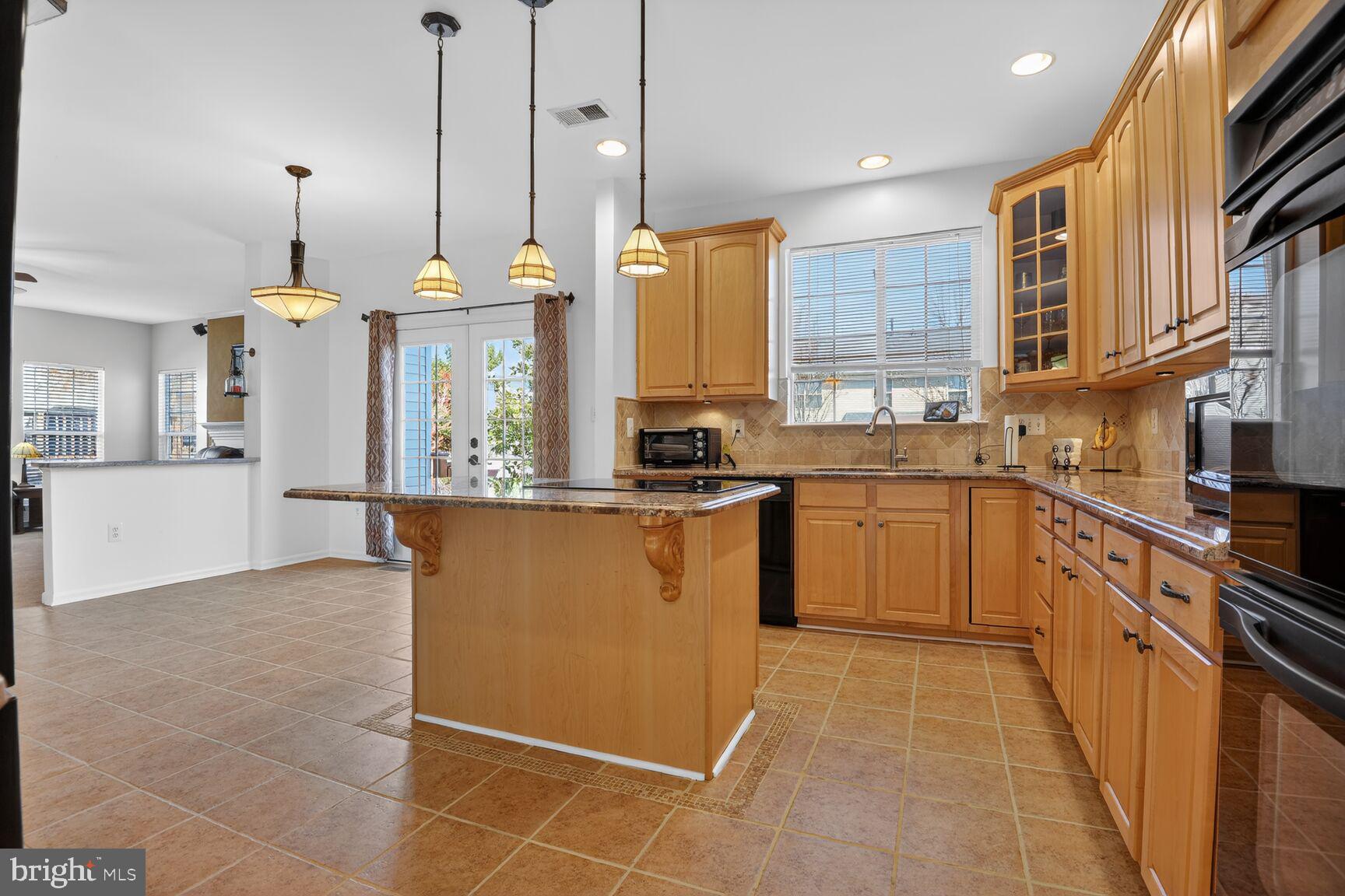 14272 Town Commons Way Gainesville, VA 20155 - Photo 7 of 32 a kitchen with stainless steel appliances granite countertop a sink a stove and a refrigerator