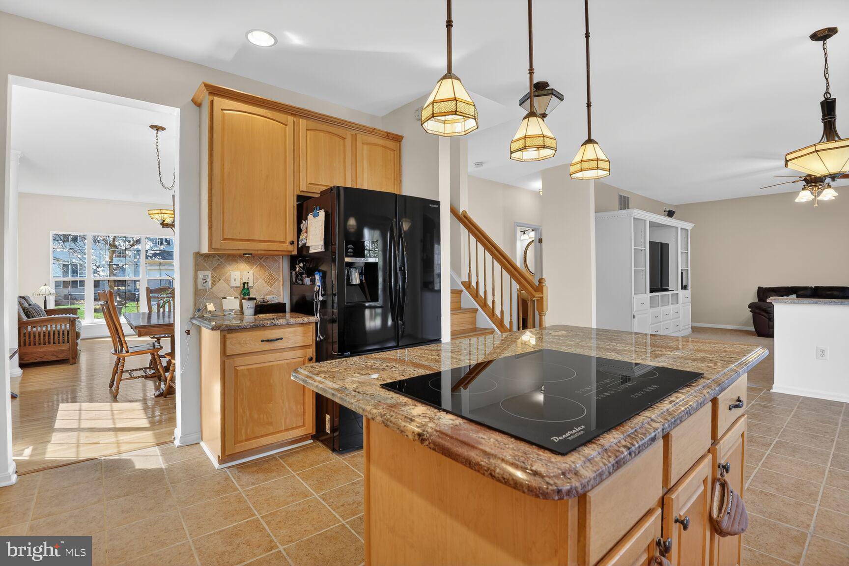 14272 Town Commons Way Gainesville, VA 20155 - Photo 8 of 32 a kitchen with stainless steel appliances granite countertop a sink a stove and a refrigerator
