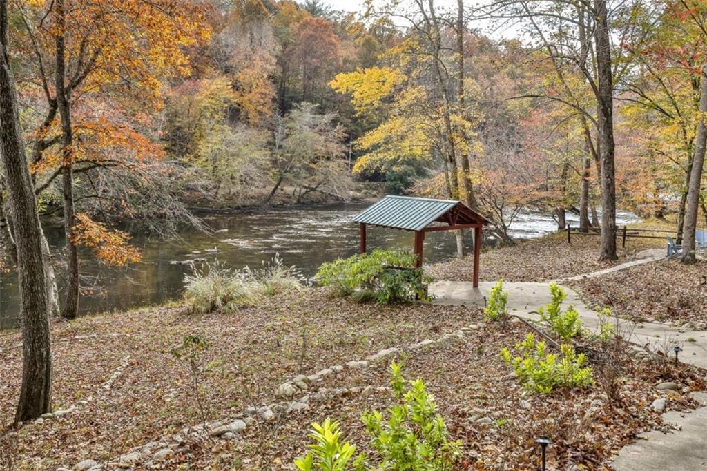 178 Novena Court Ellijay, GA 30540 - Photo 49 of 88 a backyard of a house with table and chairs under an umbrella