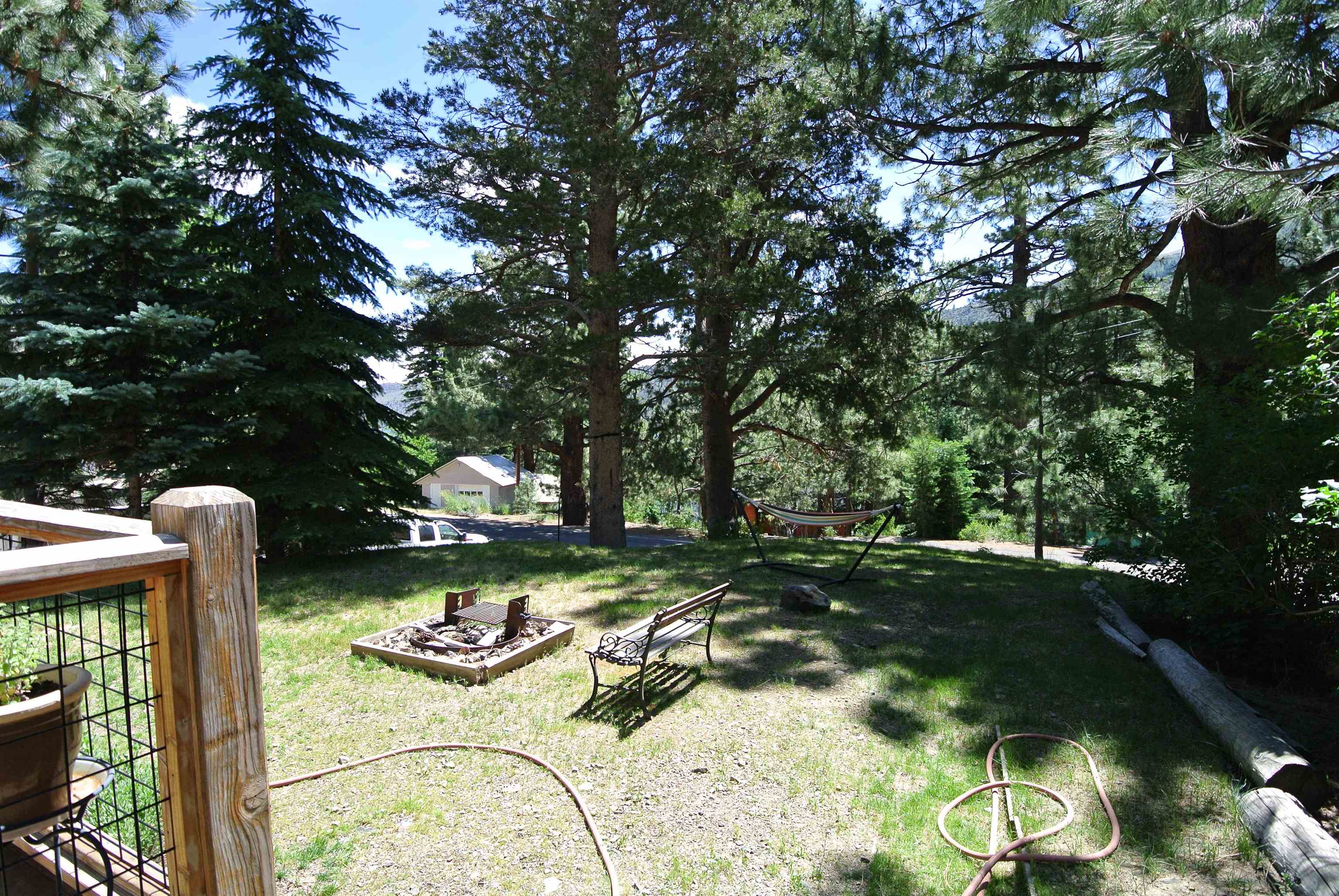 11702 Twin Lakes Road Bridgeport, CA 93517 - Photo 4 of 21 Expansive outdoor space featuring a fire pit, mature trees, and a visible wood deck with wire railing