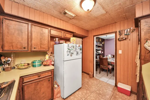 a kitchen with a refrigerator and table chairs