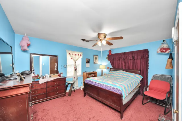 a bedroom with a bed and dresser with mirror