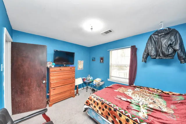 a bedroom with a bed and a window