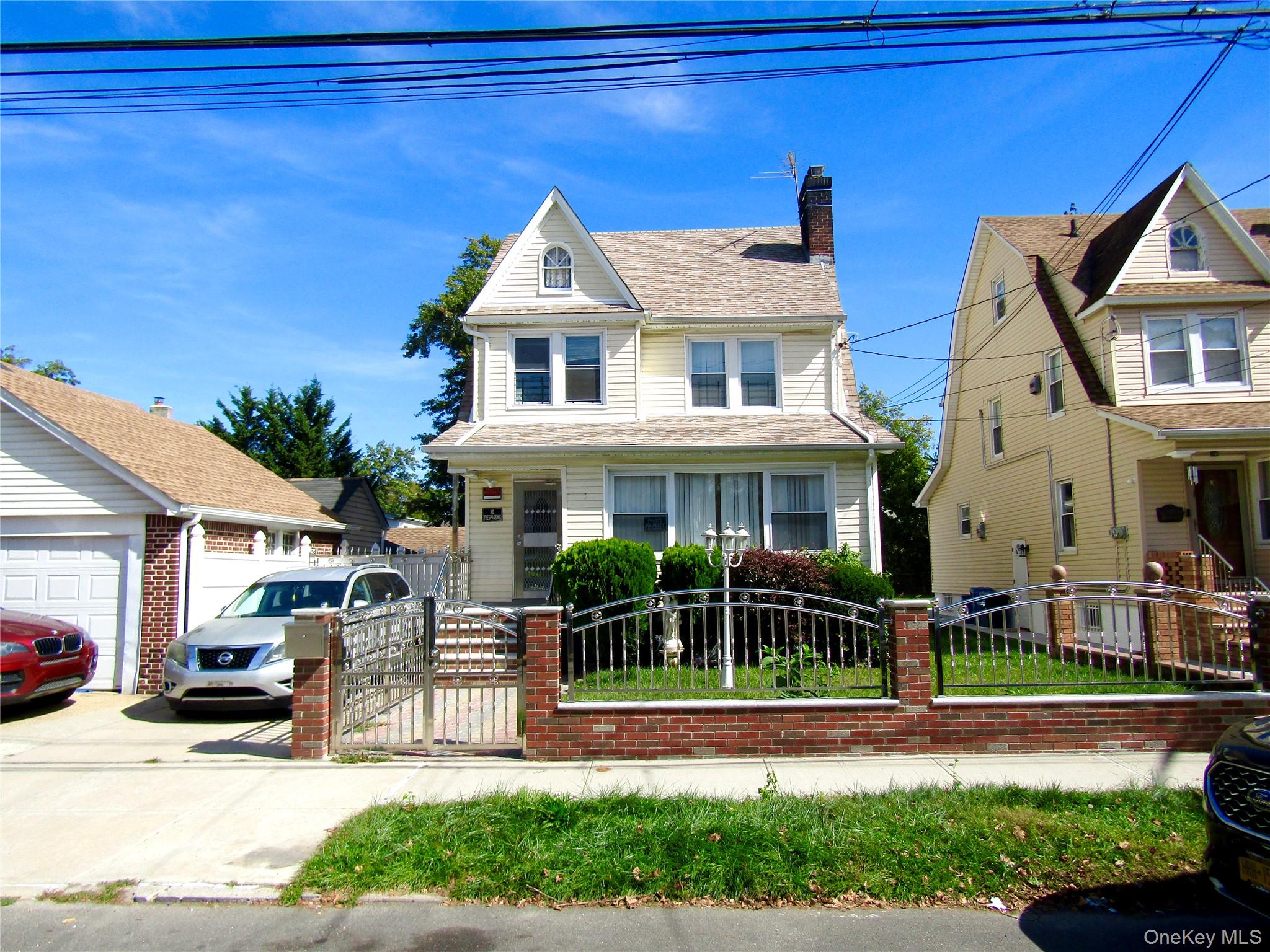 View of front facade with a chimney, a gate, a fenced front yard, and a shingled roof