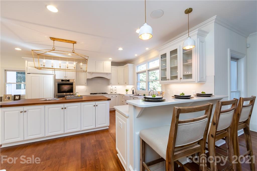 4407 Oglukian Road Charlotte, NC 28226 - Photo 10 of 48 a kitchen with granite countertop white cabinets and chairs