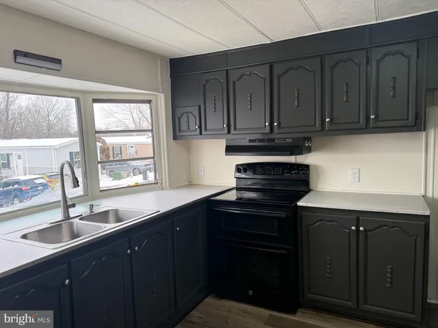 a kitchen with granite countertop a sink stainless steel appliances and cabinets