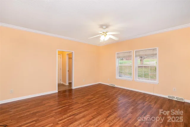 an empty room with wooden floor and window