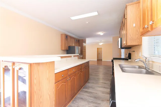 a large kitchen with stainless steel appliances a sink and cabinets
