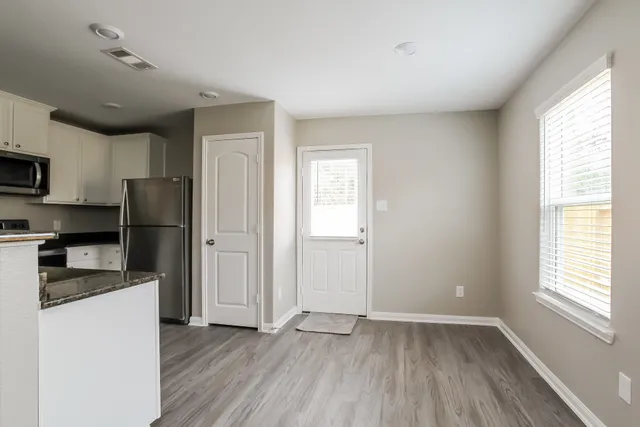 a kitchen with a refrigerator and a stove top oven