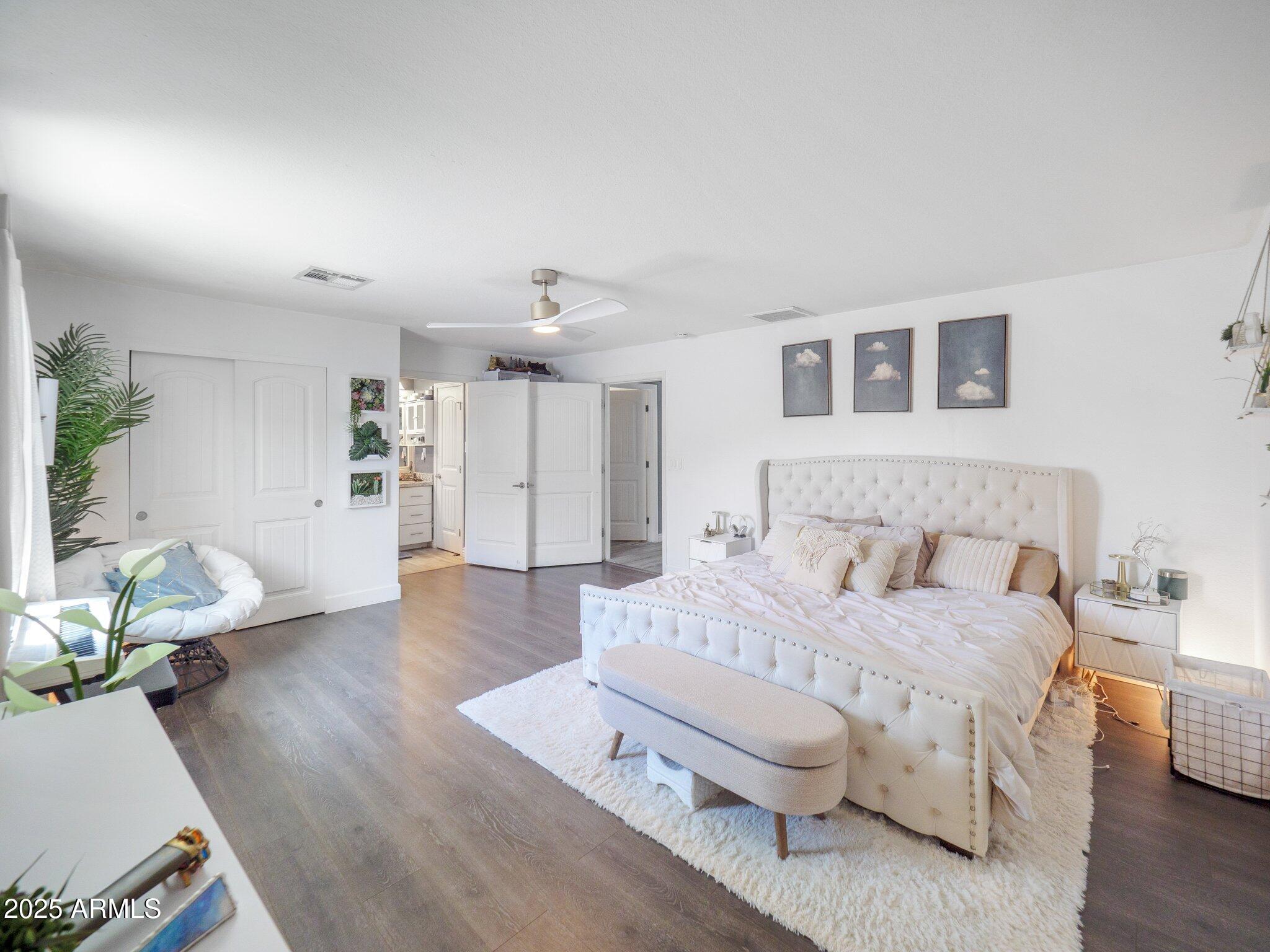 8728 East Monte Vista Road Scottsdale, AZ 85257 - Photo 12 of 28 a spacious bedroom with a bed and wooden floor