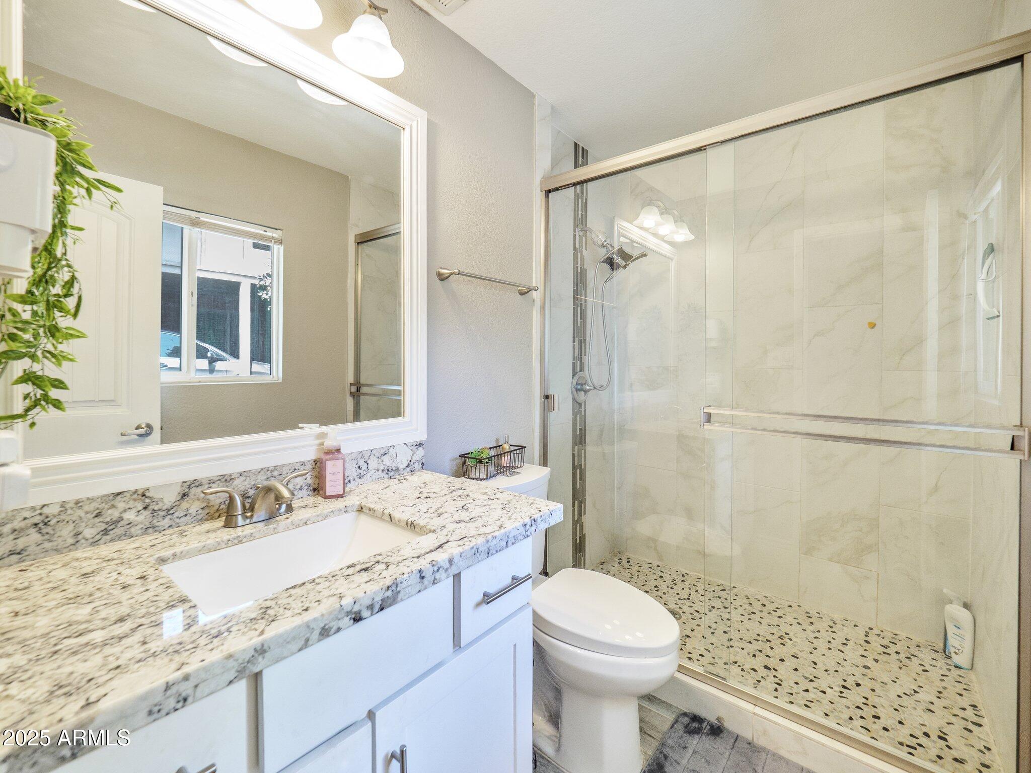 8728 East Monte Vista Road Scottsdale, AZ 85257 - Photo 15 of 28 a bathroom with a granite countertop sink toilet and shower