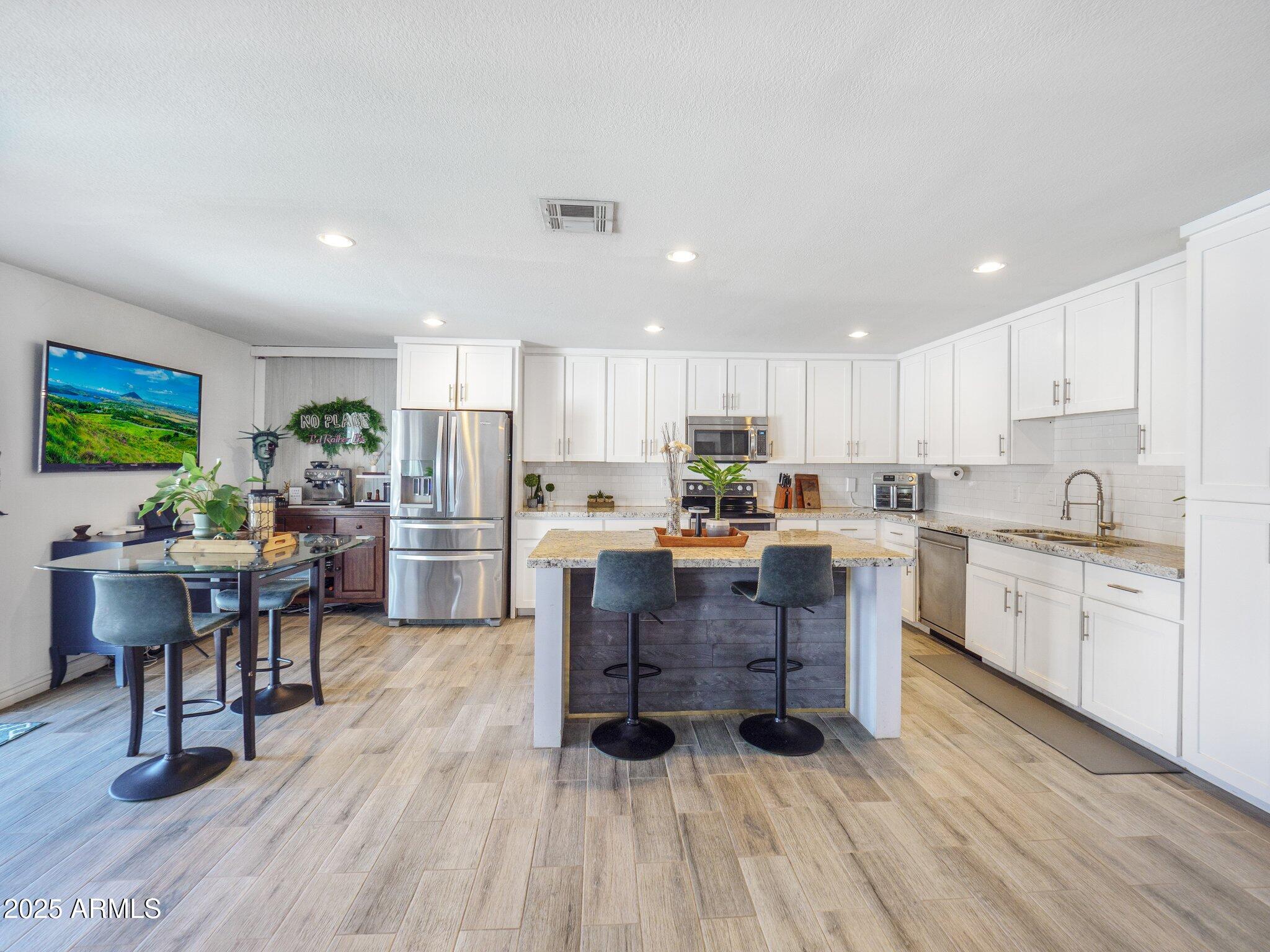8728 East Monte Vista Road Scottsdale, AZ 85257 - Photo 6 of 28 a kitchen with a table chairs microwave and cabinets