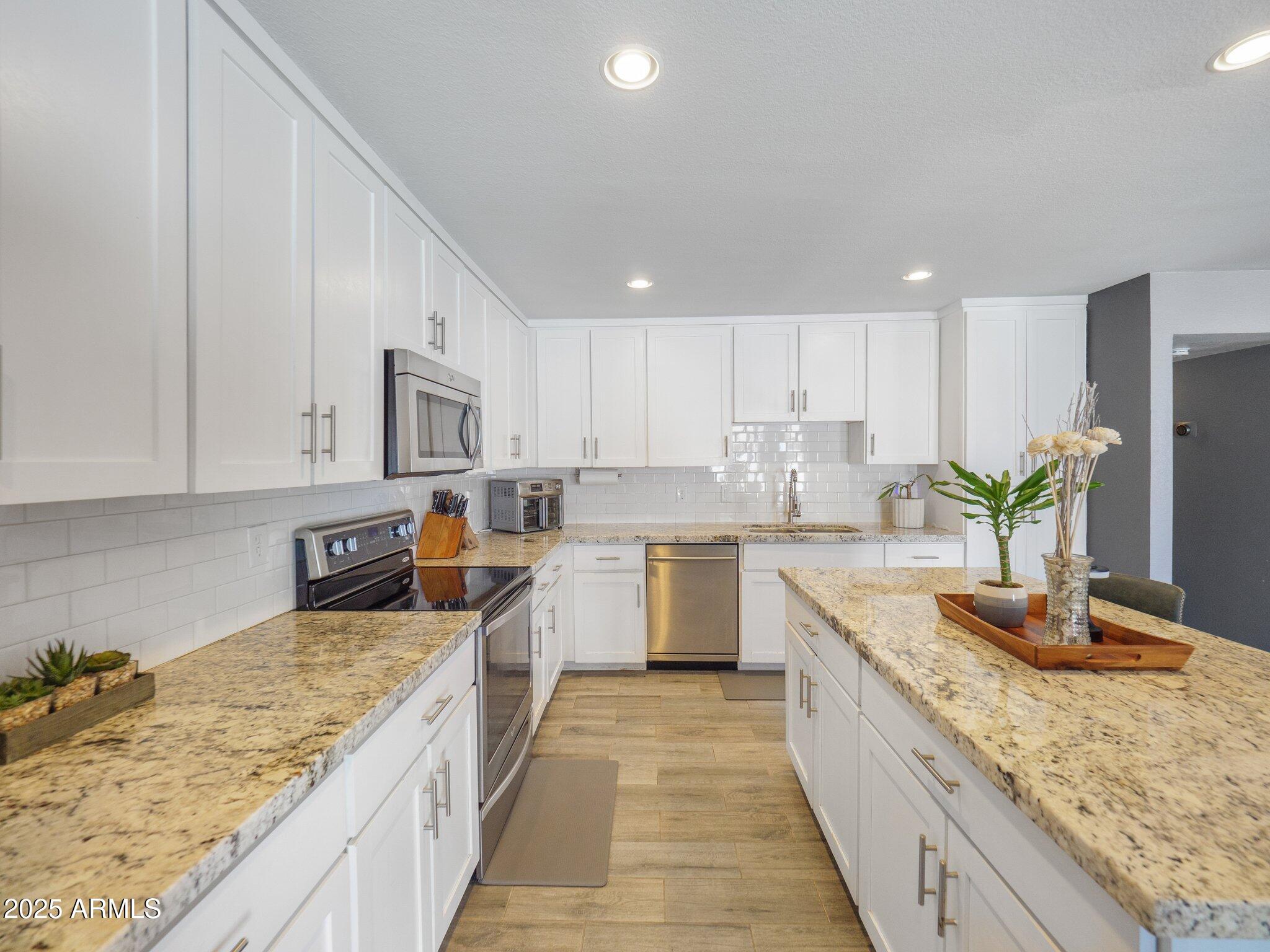 8728 East Monte Vista Road Scottsdale, AZ 85257 - Photo 8 of 28 a large kitchen with granite countertop a sink a counter top space and cabinets