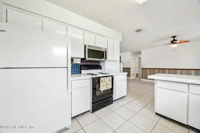 a kitchen with a refrigerator and a stove top oven