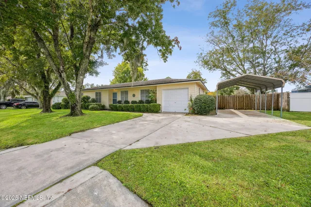 a front view of a house with yard and green space