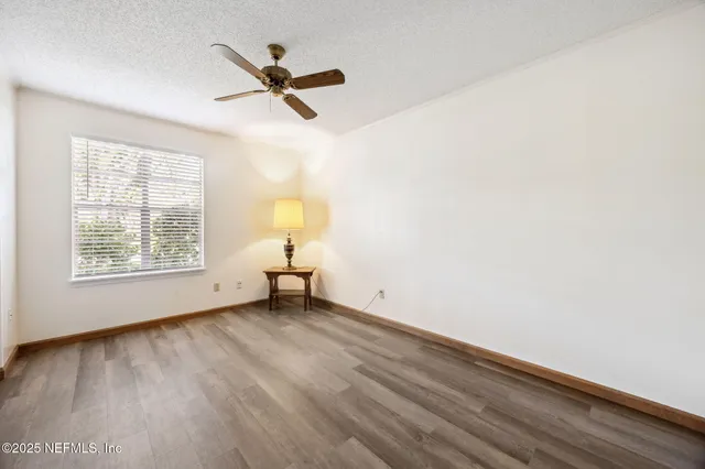 a view of a room with a window and wooden floor